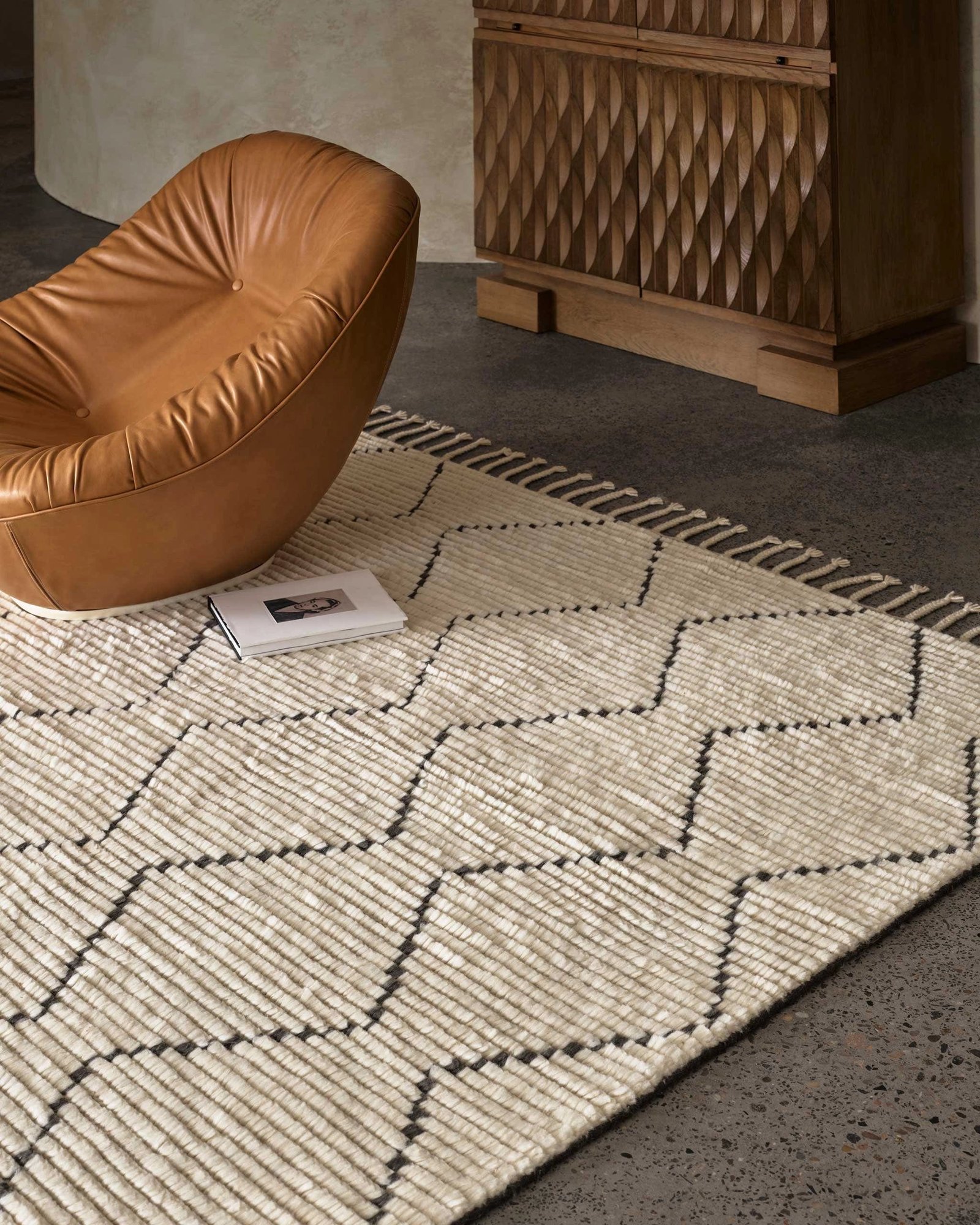 Handwoven wool rug with geometric diamond pattern in natural and slate tones and zigzag design