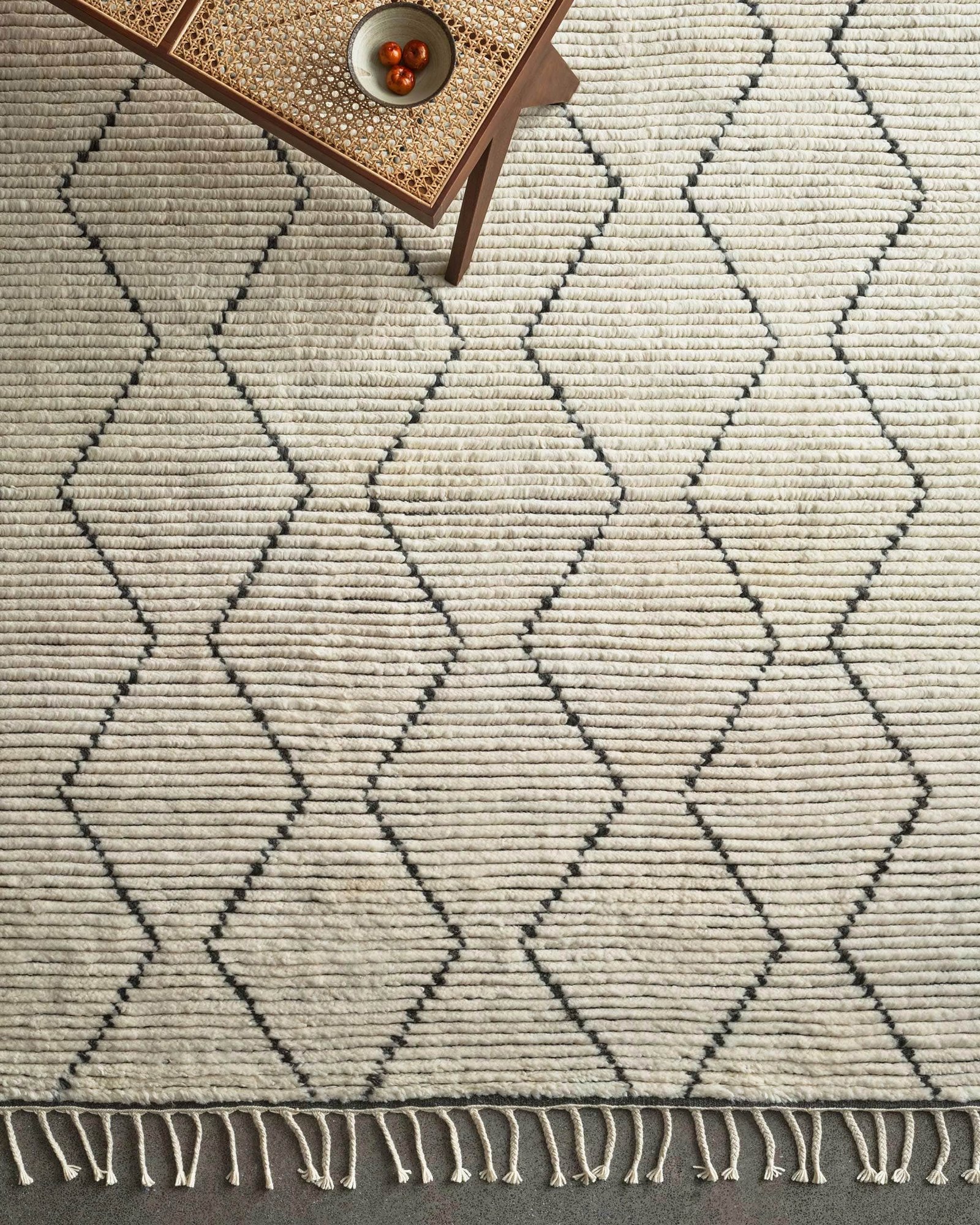 Handwoven wool rug with geometric diamond pattern in natural and slate tones and zigzag design